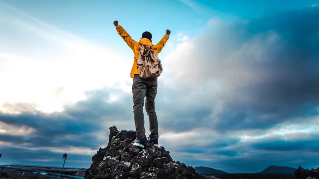 victory-adventurous-person-reaches-mountain-top-raising-ar-2026-09-21